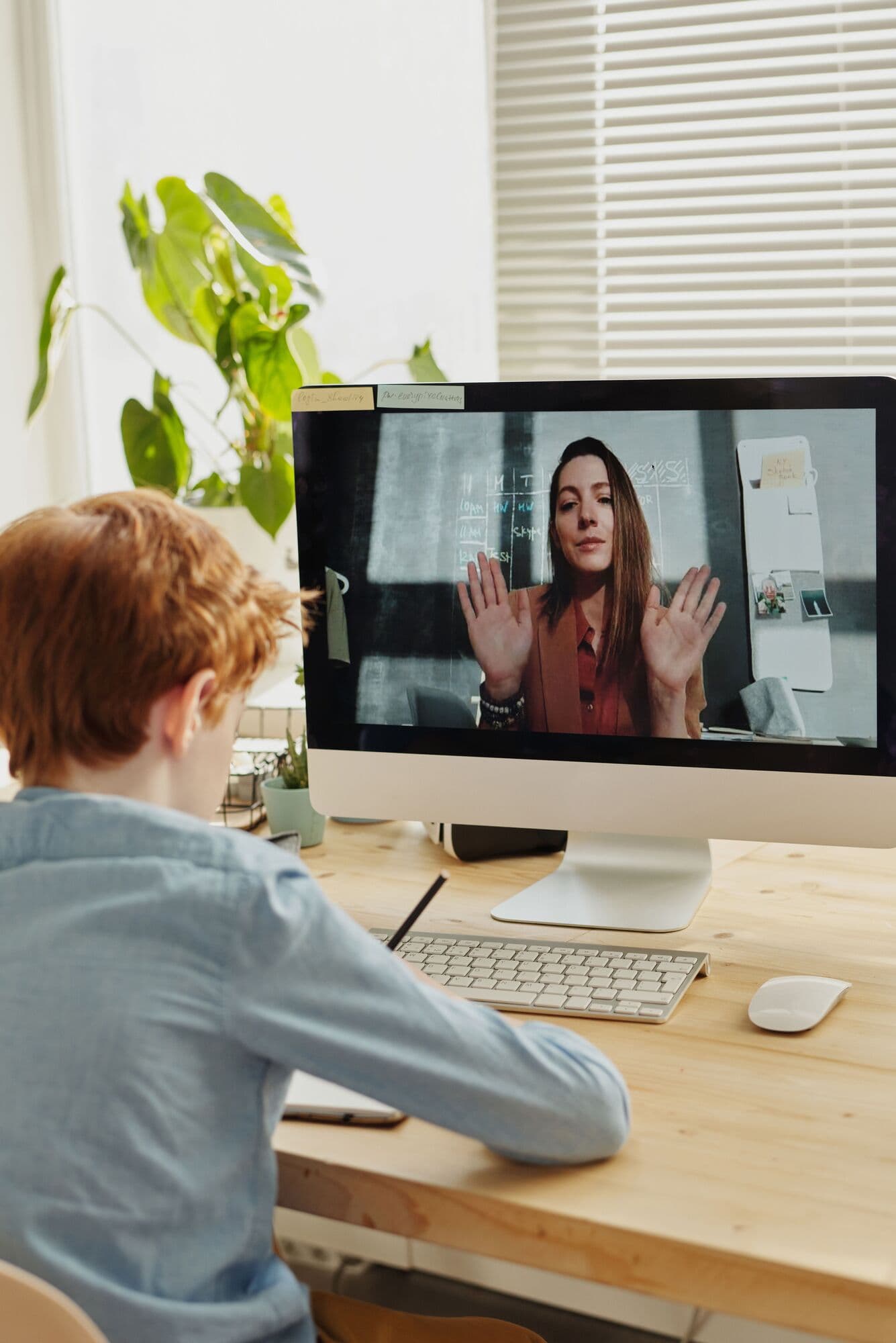 A tutor waves to her learner on screen